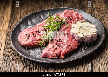 Meeat steak Faux-filet de boeuf au romarin avec du sel et du poivre sur la plaque noire Banque D'Images