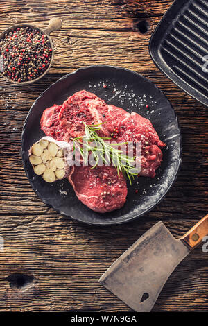 Meeat steak Faux-filet de boeuf au romarin avec du sel et du poivre sur la plaque noire Banque D'Images