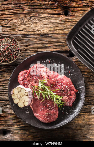 Meeat steak Faux-filet de boeuf au romarin avec du sel et du poivre sur la plaque noire Banque D'Images