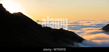 Vue sur la silhouette du télésièges et de montagnes couvertes de brume au lever du soleil vu depuis le Col du Tourmalet, Pyrénées, France, juin 2012 Banque D'Images