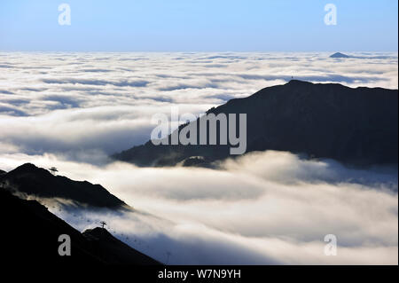 Vue sur la silhouette du télésièges et de montagnes couvertes de brume au lever du soleil vu depuis le Col du Tourmalet, Pyrénées, France, juin 2012 Banque D'Images