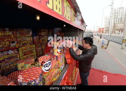 --FILE--un résident chinois local achète d'artifice pour la fête du printemps, ou le Nouvel An Chinois (année du singe), dans un établissement d'artifice Banque D'Images