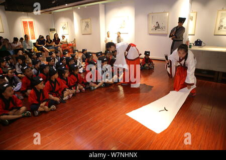 Les élèves apprennent à écrire le caractère chinois "REN", qui signifie "humain" en anglais, à la première cérémonie d'écriture dans la ville de Binzhou, East China's Beijing Banque D'Images