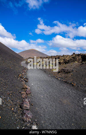 L'Espagne, Lanzarote, beau sentier de marche aux côtés de majestueux volcan el Cuervo par des champs de lave Banque D'Images