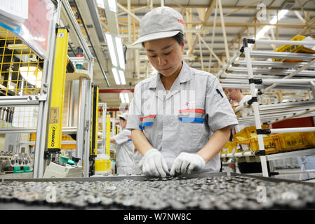 --FILE--une femme travailleur chinois vérifie les pièces d'automobile à une usine d'automobiles dans la ville de Xiangfan, province de Hubei en Chine centrale, 26 juin 2017. La Chine dom brut Banque D'Images