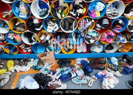 Chaussures de vacanciers chinois sont placés dans des tubes de stockage dans un parc aquatique à Wuhan, province du Hubei en Chine centrale, 22 juillet 2017. Au-delà d'un fe Banque D'Images