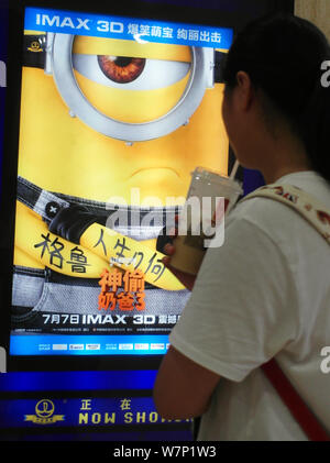 Un filmgoer chinois ressemble à une affiche du film 'Despicable Me 3" dans un cinéma à Yichang city, le centre de la Chine, la province du Hubei, le 8 juillet 2017. Le de Banque D'Images