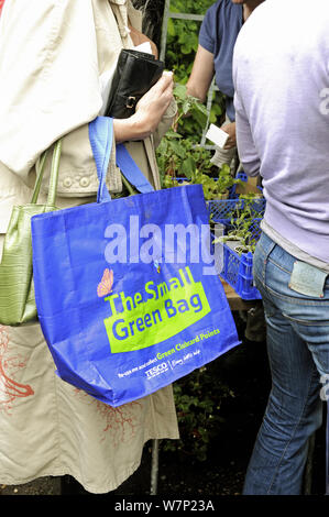 Le vert petit sac, sac réutilisable de Tesco détenues par femme dans la file d'attente à l'usine vente, London UK Banque D'Images