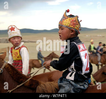 Les jeunes cavaliers mongols participer à course de chevaux durant le festival Naadam Banque D'Images