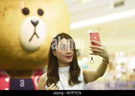 Un touriste pose pour une photo lors de l'exposition de 'la maison d'AMIS EN LIGNE Choco' dans la ville de Hangzhou, Zhejiang Province de Chine orientale, le 26 juin 2017. Le spectacle des ' Banque D'Images