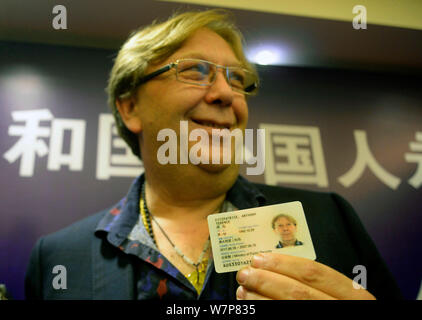 Un étranger présente sa carte d'identité de résident permanent au cours de la cérémonie de lancement pour remplacer les cartes vertes pour les étrangers avec les smart cards' qui s'est tenue à Hangzhou Banque D'Images