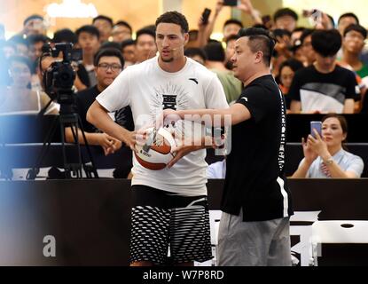 Joueur américain de basket-ball de Klay Thompson, centre, montre des compétences de basket-ball pendant un événement promotionnel à Zhengzhou, province du Henan en Chine centrale Banque D'Images