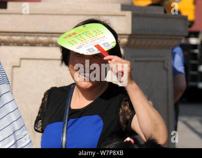 Un touriste shields elle-même avec un chapeau en forme d'ombrelle d'un soleil de plomb alors qu'elle visite la place Tian'anmen à Beijing, Chine, 15 juin 2017. Chi Banque D'Images