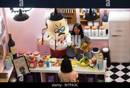 Un touriste pose pour une photo lors de l'exposition de 'la maison d'AMIS EN LIGNE Choco' dans la ville de Hangzhou, Zhejiang Province de Chine orientale, le 26 juin 2017. Le spectacle des ' Banque D'Images