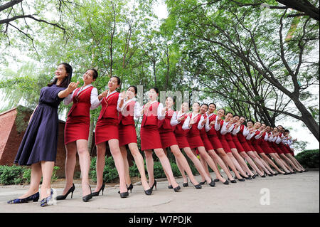 Les femmes diplômées des principaux agents de bord habillés en uniforme d'hôtesse de l'air, prendre des photos de gradation à Taiyuan city, au nord la province de Shanxi, Banque D'Images