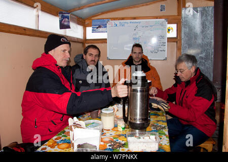 L'heure du déjeuner à l'intérieur de la cabine en bois principale sur des luges, cercle arctique, centre de plongée, mer Blanche, la Carélie, dans le Nord de la Russie, Mars 2010 Banque D'Images