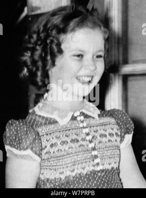 Vintage photo d'enfant américain film star Shirley Temple (1928 - 2014). La photo a été prise le 24 juin 1938 que la jeune actrice a quitté la Maison Blanche à la suite d'une réunion avec le président américain Franklin D. Roosevelt. Au cours de leur conversation, elle a dit au président comment elle avait perdu une dent la nuit avant qu'il ne tombe que lorsqu'elle a mangé un sandwich. Banque D'Images