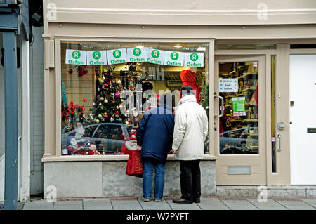 Couple à l'extérieur de la boutique d'Oxfam, juste avant Noël, Highgate Village London, England, UK, Décembre 2009 Banque D'Images