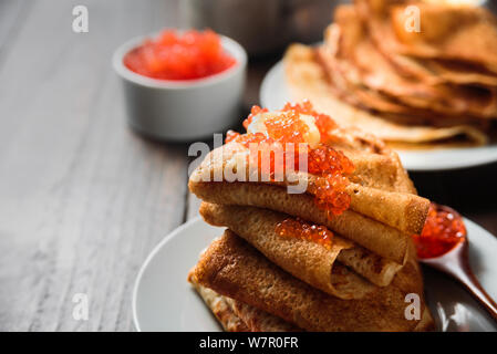 Crêpes russes blinis avec du caviar rouge sur fond de bois Banque D'Images