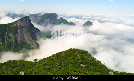 Vue aérienne de la montagne Tianmen (ou montagne Tianmenshan) entourée de nuages dans le parc forestier national de Zhangjiajie dans la ville de Zhangjiajie, central Ch Banque D'Images