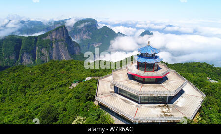 Vue aérienne de la montagne Tianmen (ou montagne Tianmenshan) entourée de nuages dans le parc forestier national de Zhangjiajie dans la ville de Zhangjiajie, central Ch Banque D'Images