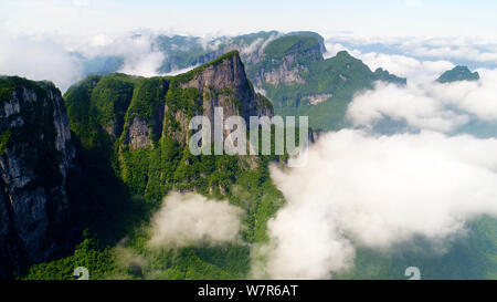 Vue aérienne de la montagne Tianmen (ou montagne Tianmenshan) entourée de nuages dans le parc forestier national de Zhangjiajie dans la ville de Zhangjiajie, central Ch Banque D'Images