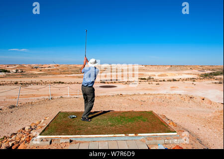L'homme jouant le golf en deserrt à Coober Pedy, un désert de l'outback, ville minière de l'opale, l'Australie du Sud Banque D'Images