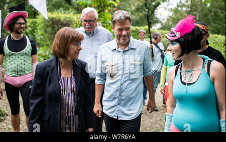 Rathenow, Allemagne. 07Th Aug 2019. Robert Habeck (M), Président fédéral de Bündnis 90/Die Grünen, Ursula et Nonnemacher (2e de gauche), le premier candidat du Brandebourg verts, en collaboration avec Stefan Behrens (3e de gauche), Vert pour candidat direct 4 circonscription, visitez le "groupe tinknormale Superhelden' après un événement de la campagne électorale pour la prochaine élection d'état dans le Brandebourg. L'initiative poursuit l'éducation à l'environnement en costume de super-héro. Crédit : Bernd von Jutrczenka/dpa/Alamy Live News Banque D'Images