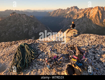 Femme appréciant les vues du sommet au coucher du soleil après une ascension au sommet du Liberty Bell via la route Beckey, près de Washington, North Cascades, Washington, USA , juillet 2013 Banque D'Images