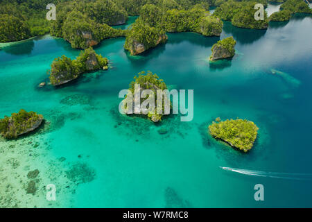 Îles calcaires de la baie Kabui, près de l'extrémité est du passage entre le GAM et Waigeo. L'île de Waigeo en haut, avec la position de bateau local pour le passage. Îles Raja Ampat, Papouasie occidentale, en Indonésie. Octobre 2010 Banque D'Images
