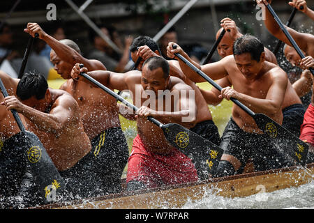 Les participants concourent dans une course de bateaux-dragons sur une rivière pour célébrer le prochain Dragon Boat Festival, également connu sous le nom de Duanwu Festival, dans la ville de Guangzhou Banque D'Images