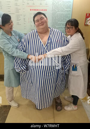 Homme âgé de 26 ans Huang Tao (pseudonyme), centre, qui est censé être l'homme le plus lourd en Chine, est entouré de deux travailleurs médicaux avant une chirurgie Banque D'Images