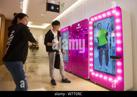 Une femme essaie sur les vêtements à l'aide d'un salon d'essayage virtuel 3D à un centre commercial à Nanjing, Jiangsu province de Chine orientale, le 8 mai 2017. Les consommateurs essayé o Banque D'Images