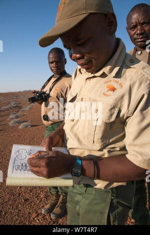 Save the Rhino Trust trackers, Tjiraso Nawaseb Denso Martin avant-plan et Epson Rukama à Desert Rhino camp, Wilderness Safaris, région de Kunene, Namibie, Mai 2013 Banque D'Images