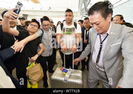 La star brésilienne du football Ronaldo Luis Nazario de Lima, centre, communément connu sous le nom de Ronaldo, est entouré de fans à l'Aéroport International de Hong Kong Banque D'Images