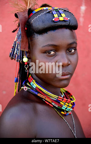 Femme Ovakahaona avec hairstyle et ornements traditionnels, avec une plume d'autruche ornant sa tête. Okongwati village, Kaokoland, la Namibie. Banque D'Images
