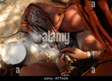 Les femmes Himba cheveux tresser les cheveux de chacun, Kaokoland, Namibie, septembre 2013. Banque D'Images