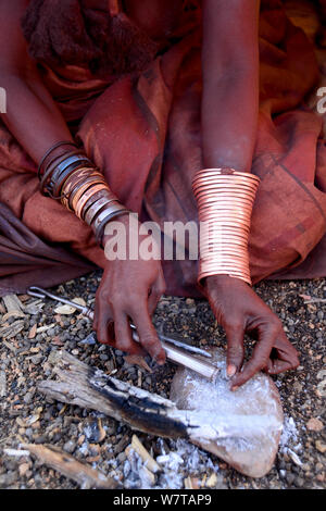 Femme Himba la préparation du tabac à priser nasal. Himba village, Kaokoland, Namibie, septembre 2013. Banque D'Images