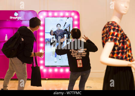 Une femme essaie sur les vêtements à l'aide d'un salon d'essayage virtuel 3D à un centre commercial à Nanjing, Jiangsu province de Chine orientale, le 8 mai 2017. Les consommateurs essayé o Banque D'Images