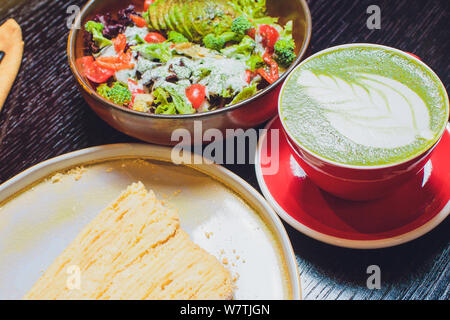 Un déjeuner de Japonais sur une table dans un restaurant, grill : le saumon, la salade, soja vert, thé matcha. Banque D'Images