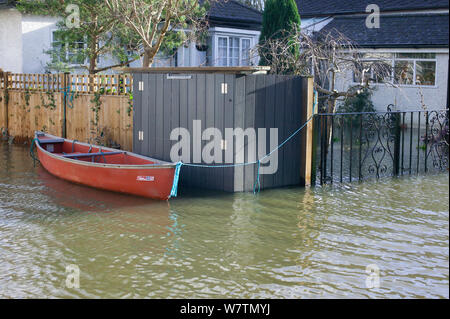 Canoe attachés à l'extérieur de la maison inondée au cours de février 2014 Inondations, Sunbury on Thames, Surrey, Angleterre, Royaume-Uni, 15 février 2014. Banque D'Images