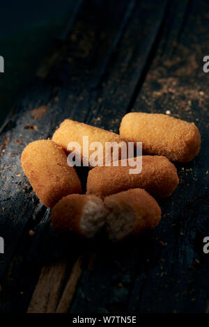 Libre de quelques croquettes espagnoles sur une table rustique en bois foncé Banque D'Images