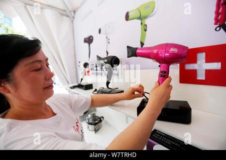 Un employé affiche swiss-made bouilloire d'un sèche-cheveux pendant la Semaine Suisse de Shanghai, Chine, 13 mai 2017. Les cinq jours de la 5e édition de la Swiss Nous Banque D'Images