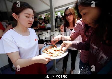 Un employé suisse distribue des cookies pour visiteurs au cours de la Semaine Suisse de Shanghai, Chine, 13 mai 2017. Les cinq jours de la 5e édition de la Semaine Suisse Banque D'Images