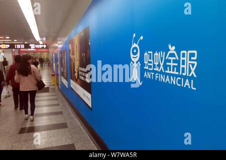 --FILE--passagers à pied passé une publicité de financière de Groupe d''Ant à une station de métro à Shanghai, Chine, 30 mars 2017. Les ant Banque D'Images
