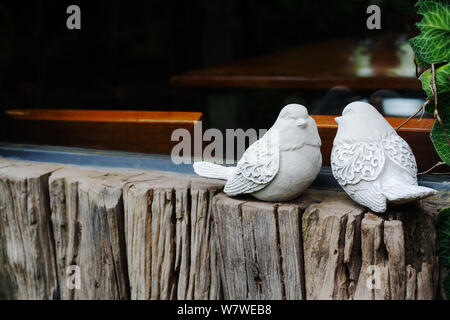 Couple d'oiseaux, deux statues d'oiseaux blancs sur la fenêtre en bois près de Banque D'Images