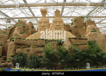 Avis de deux statues couronnant un 26 mètres de long de ses sculptures en montagne à partir de 20 000 kilogrammes de plantes gingembre lors d'une expo à Huang county, Anyang cit Banque D'Images
