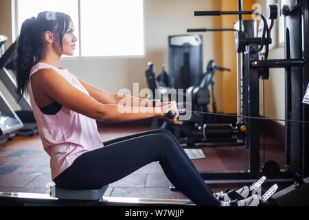 Jeune femme au travail de remise en forme dans la salle de sport Banque D'Images