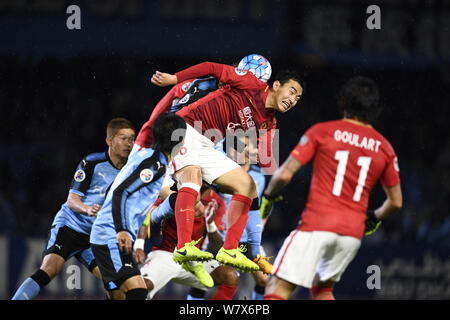 Feng Xiaoting de Chine Guangzhou Evergrande, du centre, les joueurs du Japon's Kawasaki Frontale dans leur match du groupe G au cours de l'AFC Champions Banque D'Images