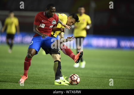 Joueur de football camerounais Christian Bassogog de Henan Jianye, gauche, défis avec Zhang Linpeng de Guangzhou Evergrande Taobao dans leur septième ro Banque D'Images